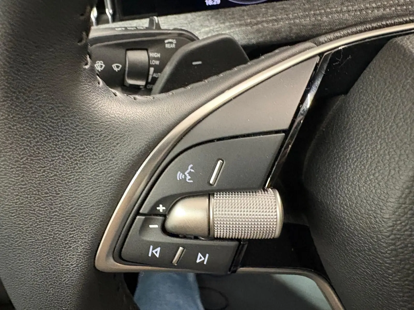 Détail du volant côté gauche du Skoda Superb Combi gris argent 2025, avec commandes audio intégrées.