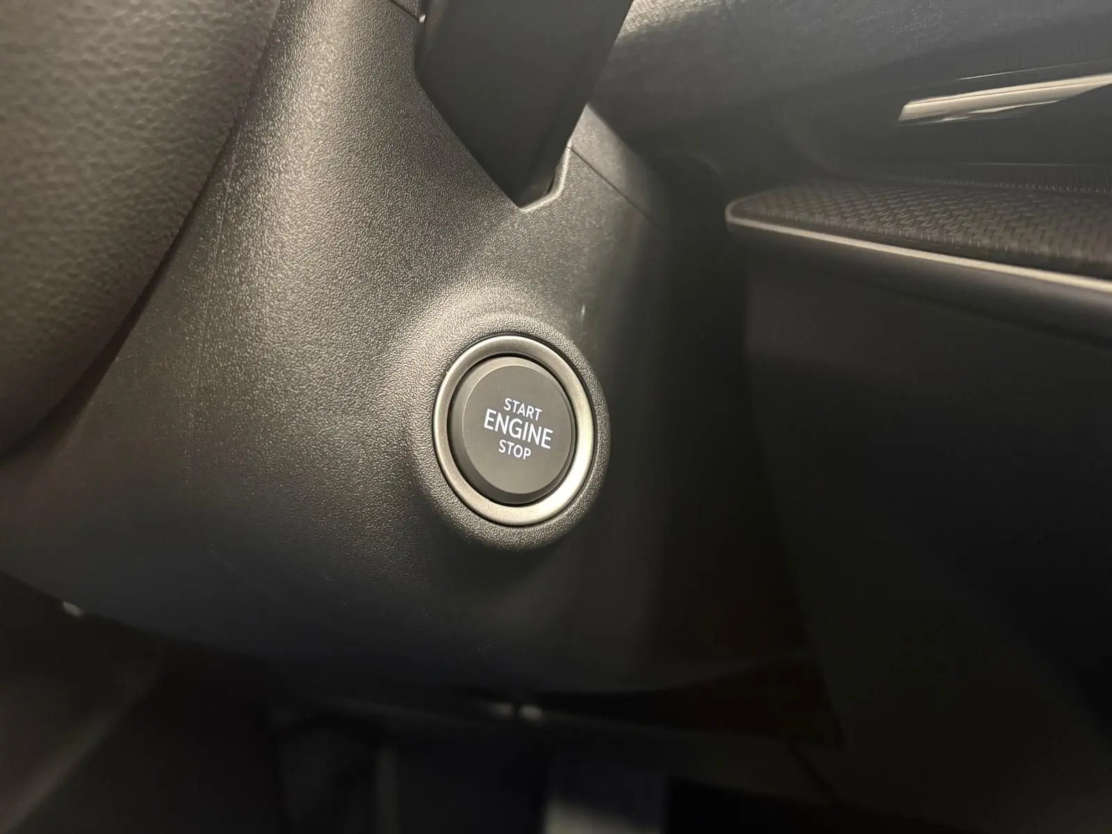 Bouton start/stop moteur en gros plan sur le tableau de bord noir du Skoda Superb Combi 2025 gris argent.