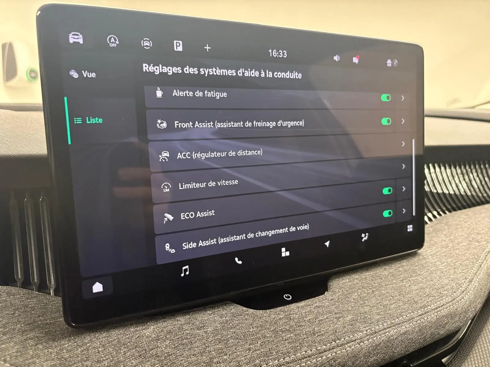 Écran tactile central affichant les réglages d'aides à la conduite dans une Skoda Superb Combi gris argent 2025.
