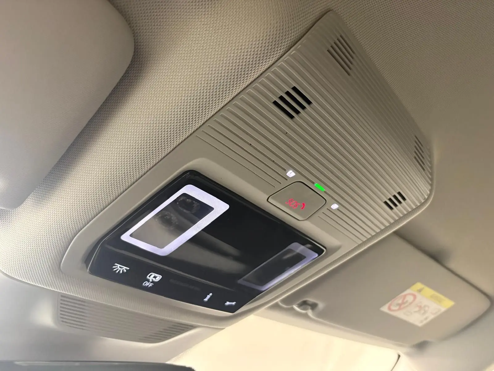 Plafonnier intérieur gris clair avec bouton SOS illuminé en rouge dans une Skoda Superb Combi gris argent 2025.