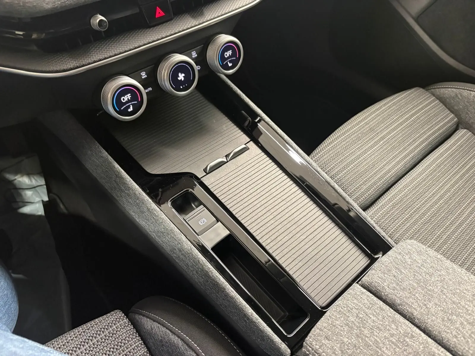 Gros plan sur la console centrale noire et les commandes de climatisation du Skoda Superb Combi gris argent 2025.