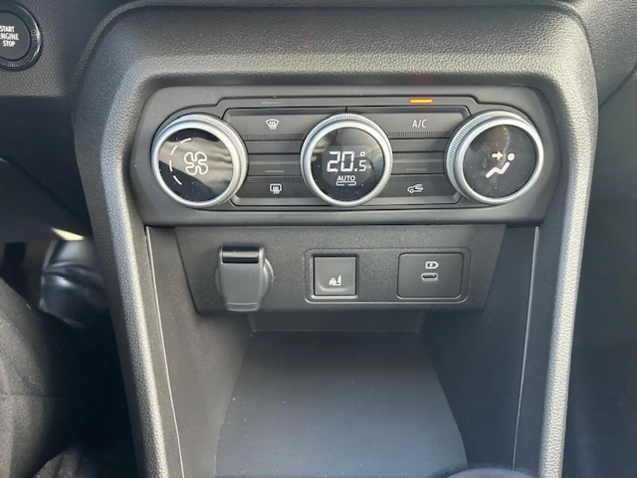 Gros plan sur la console centrale noire du Dacia Sandero Stepway 2025, montrant les commandes de climatisation digitales.