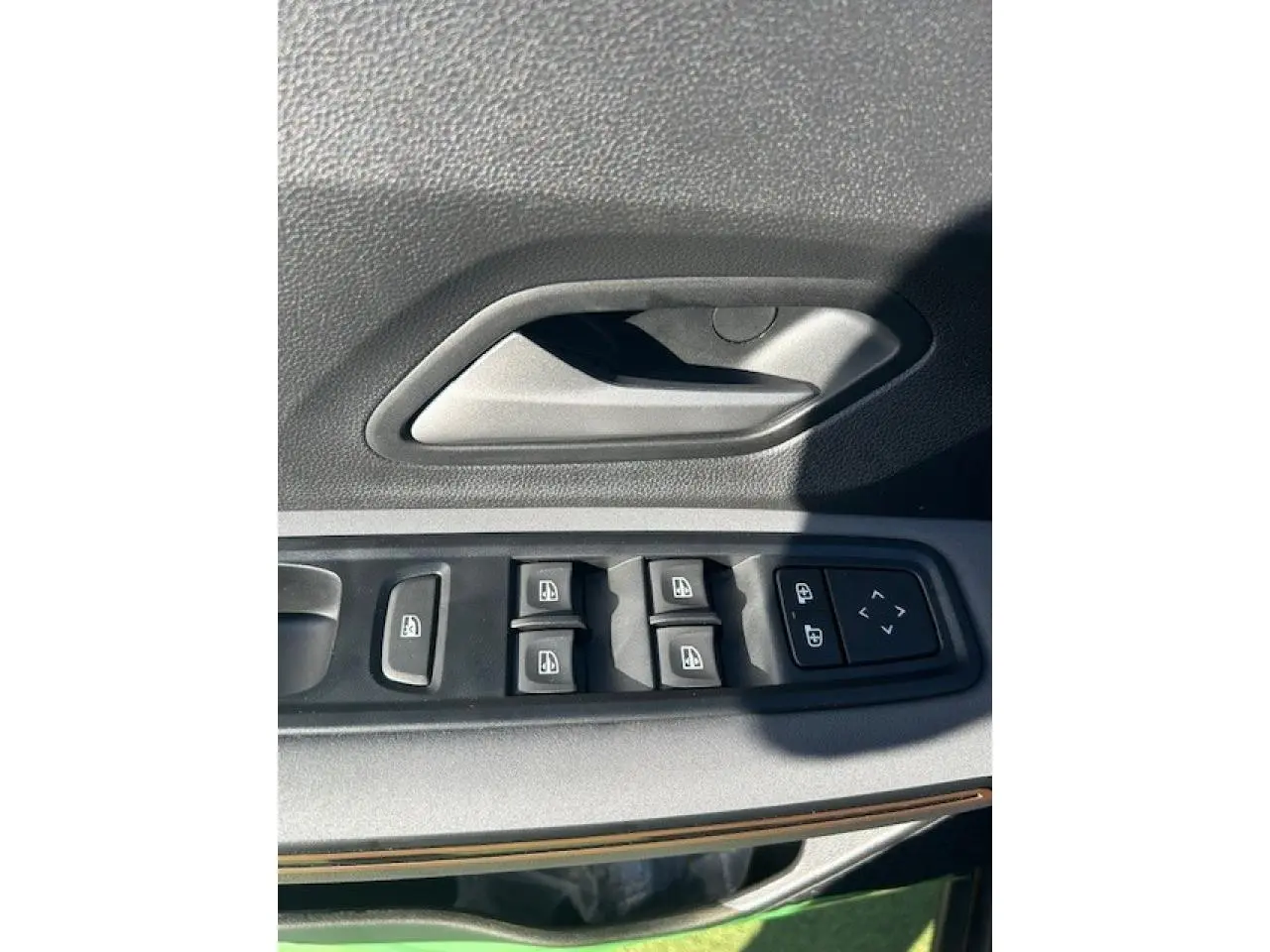 Détail des commandes de lève-vitres et verrouillage sur la porte côté conducteur d'une Dacia Sandero III Stepway noir nacré.