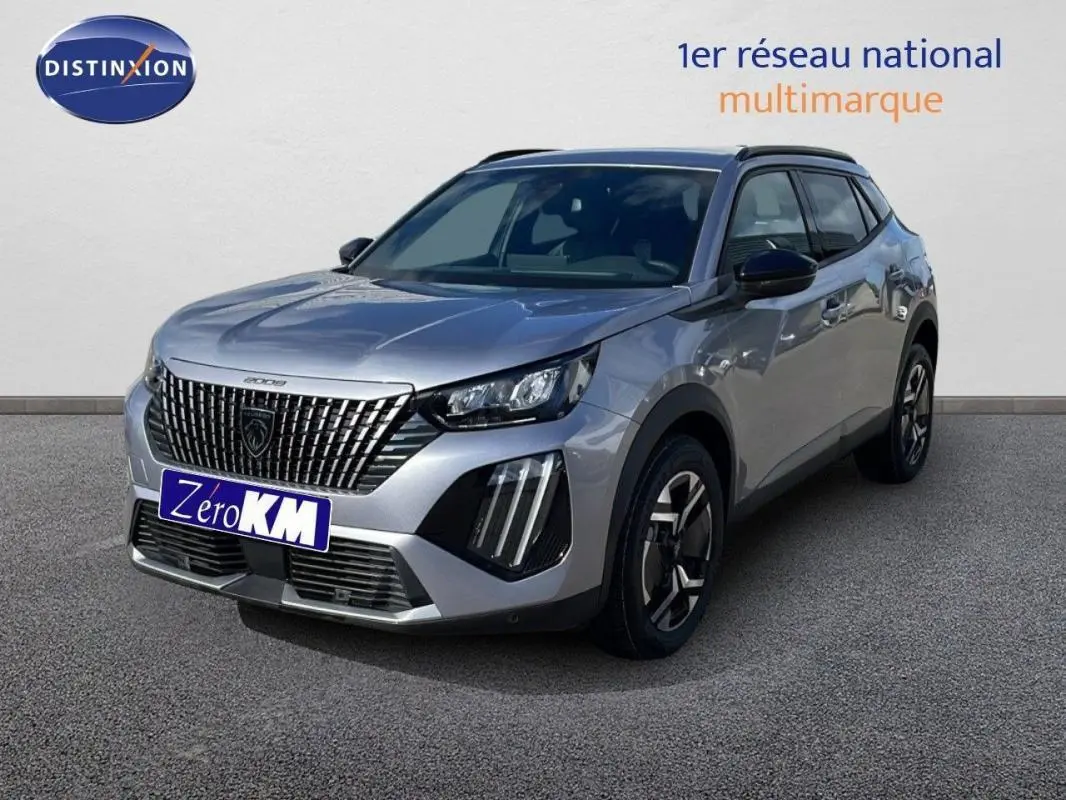 Peugeot 2008 gris en 3/4 avant droit, avec calandre verticale et barres de toit visibles.