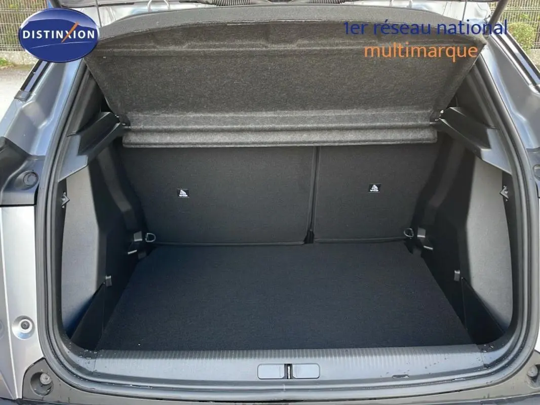 Coffre ouvert vu de l'arrière d'un Peugeot 2008 gris 2025, montrant un espace de chargement vide et propre.