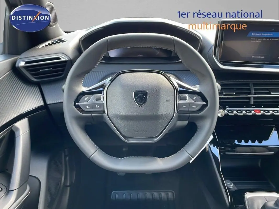 Vue frontale du volant cuir et tableau de bord noir du Peugeot 2008 gris, version 1.2 PureTech 2025 avec écran tactile.