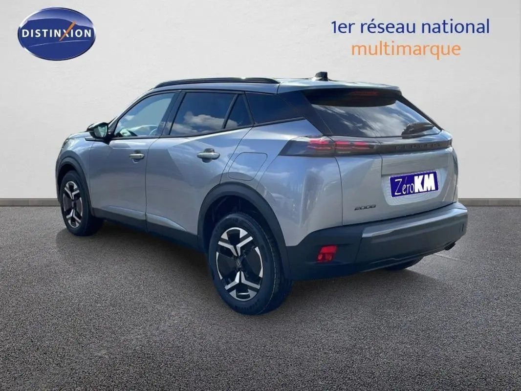 Peugeot 2008 gris en 3/4 arrière droit, avec barres de toit et jantes aluminium distinctives.