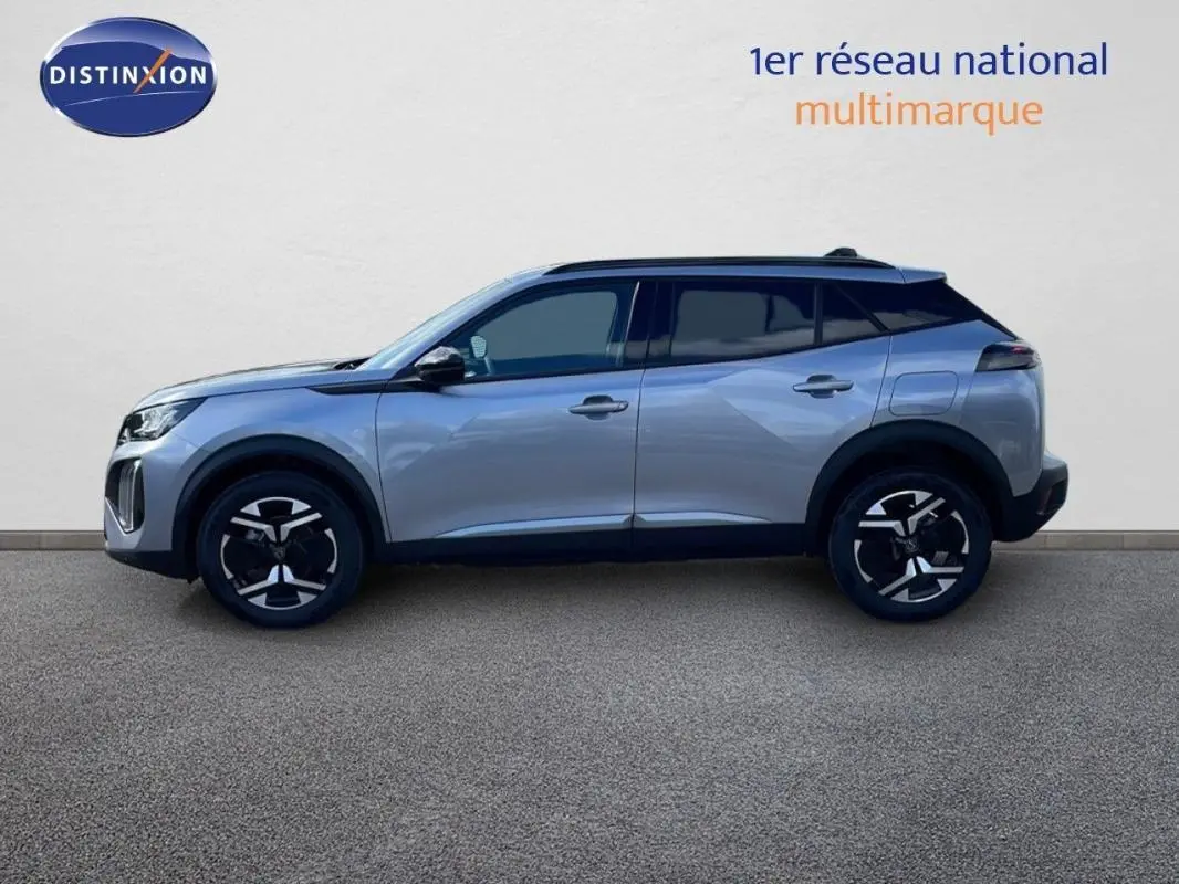 Profil droit d’un Peugeot 2008 gris 2025 avec barres de toit et jantes aluminium distinctives.