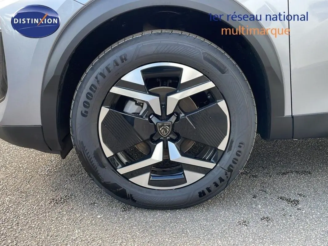 Gros plan sur la jante aluminium noire et argentée d’un Peugeot 2008 gris, côté avant droit.
