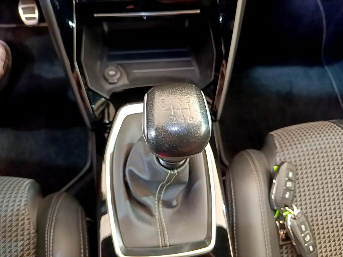 Le levier de vitesse manuel noir de la Peugeot 208 GT Line 2020, entouré de sièges gris et cuir noir.
