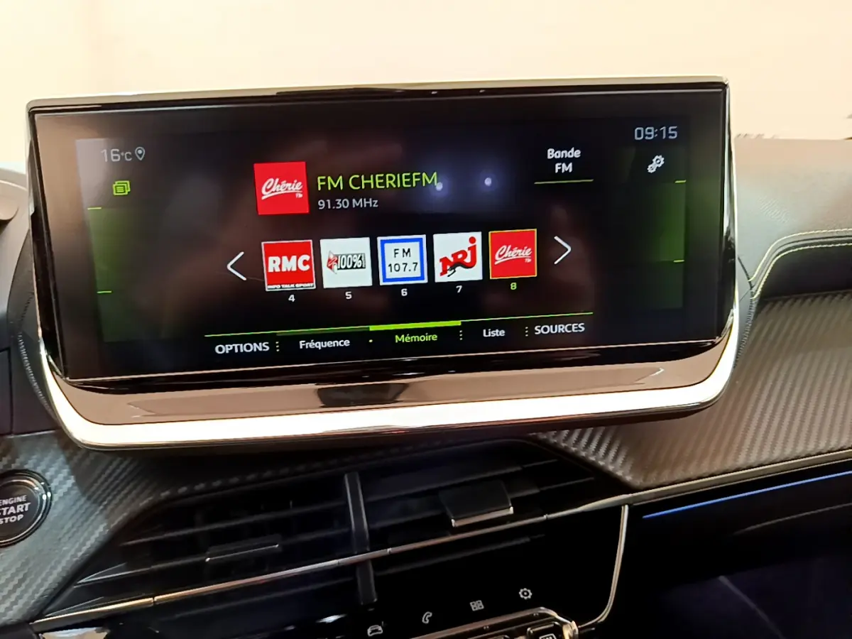 Écran tactile 10 pouces du tableau de bord de la Peugeot 208 GT Line 2020 affichant les stations radio FM.
