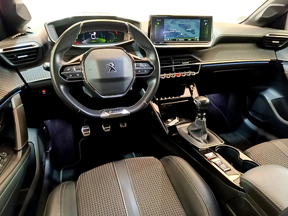 Intérieur Peugeot 208 GT Line 2020, vue du poste de conduite avec volant cuir, écran tactile 10 pouces et boîte manuelle.