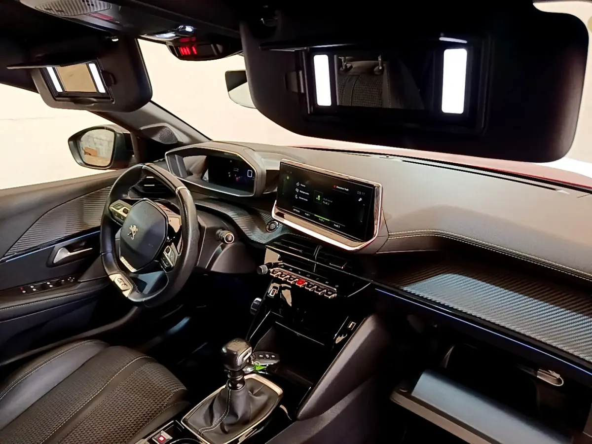Intérieur de la Peugeot 208 GT Line 2020, vue côté conducteur, tableau de bord avec écran tactile 10 pouces et volant cuir.