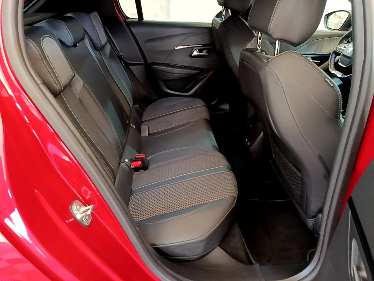 Vue intérieure côté arrière droit montrant la banquette arrière en cuir noir de la Peugeot 208 rouge GT Line 2020.
