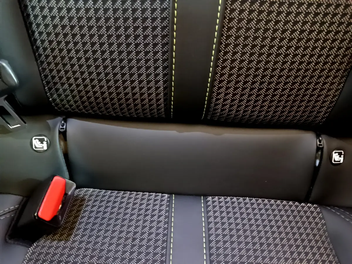 Gros plan sur la banquette arrière du Peugeot 208 GT Line 2020, tissu noir à motifs et surpiqûres vertes avec ceinture rouge.