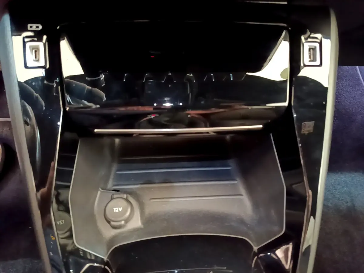 Prise 12V et rangement central noir brillant dans l'habitacle de la Peugeot 208 GT Line rouge 2020