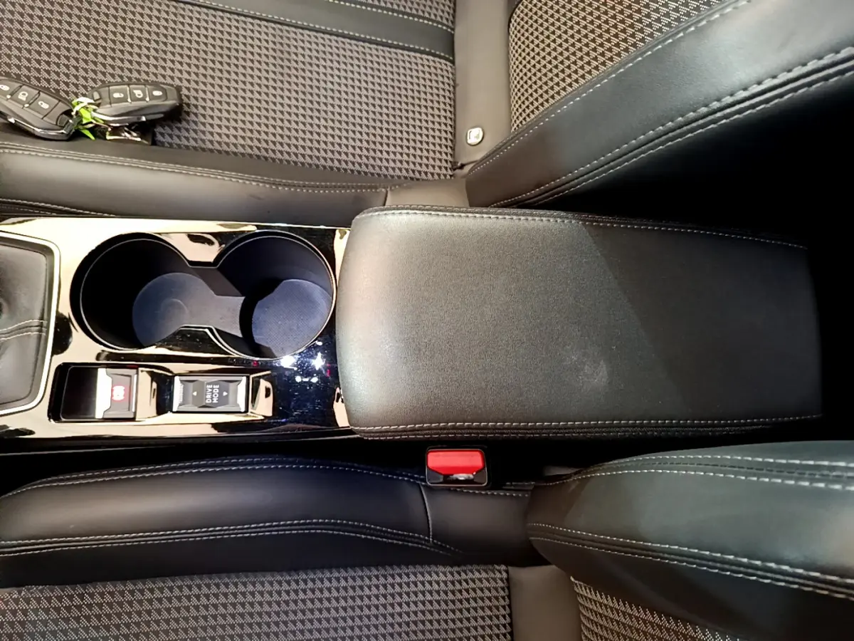 Vue plongeante sur la console centrale noire et les sièges en tissu à motifs de la Peugeot 208 GT Line rouge 2020