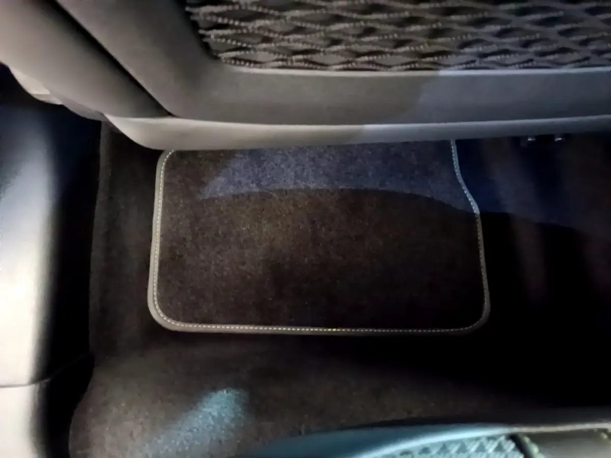 Gros plan sur le tapis de sol noir côté arrière d'une Peugeot 208 GT Line rouge de 2020.