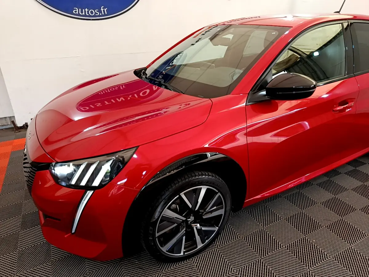 Vue 3/4 avant droit d'une Peugeot 208 GT Line rouge avec phares LED et jantes alliage noires.