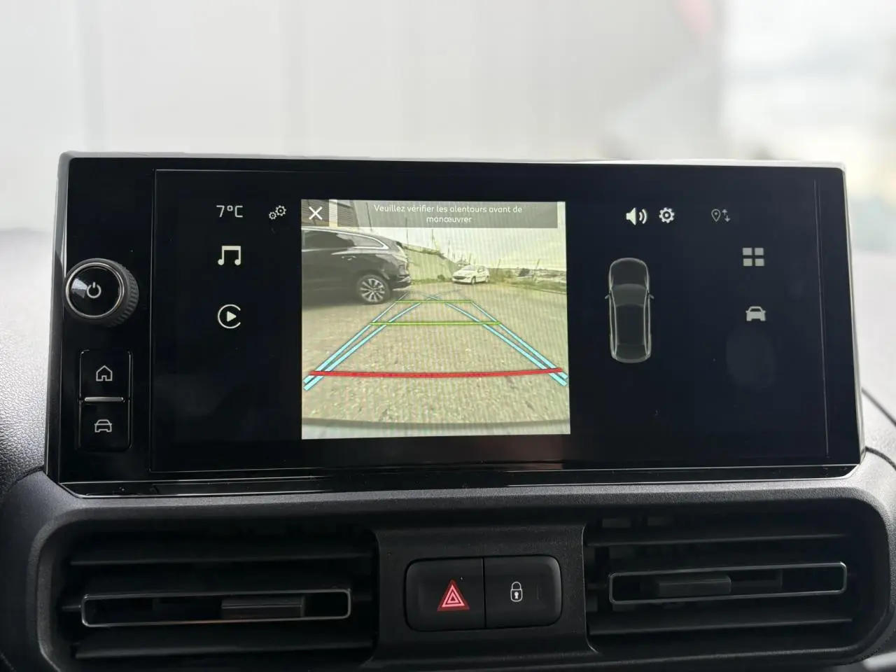 Écran tactile du Citroën Berlingo 2025 affichant la caméra de recul avec vue arrière sur un parking extérieur.