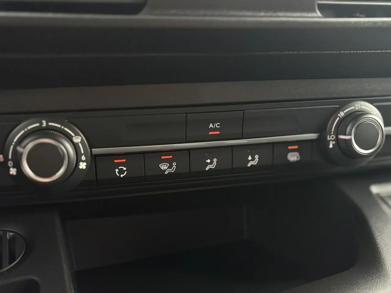 Gros plan sur la console de climatisation du Citroën Berlingo blanc Icy 2025 avec commandes manuelles et affichage A/C allumé.