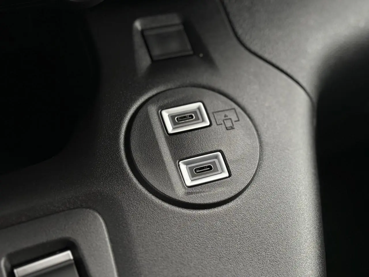 Gros plan sur deux ports USB-C intégrés dans la console centrale noire du Citroën Berlingo blanc Icy 2025.