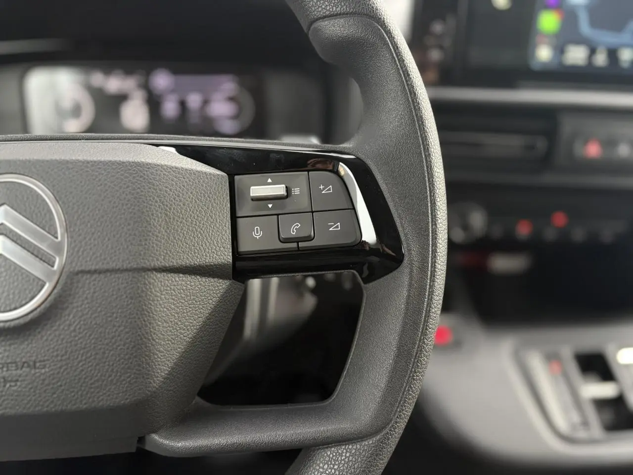 Gros plan sur la partie droite du volant du Citroën Berlingo 2025 avec commandes audio et téléphone intégrées.
