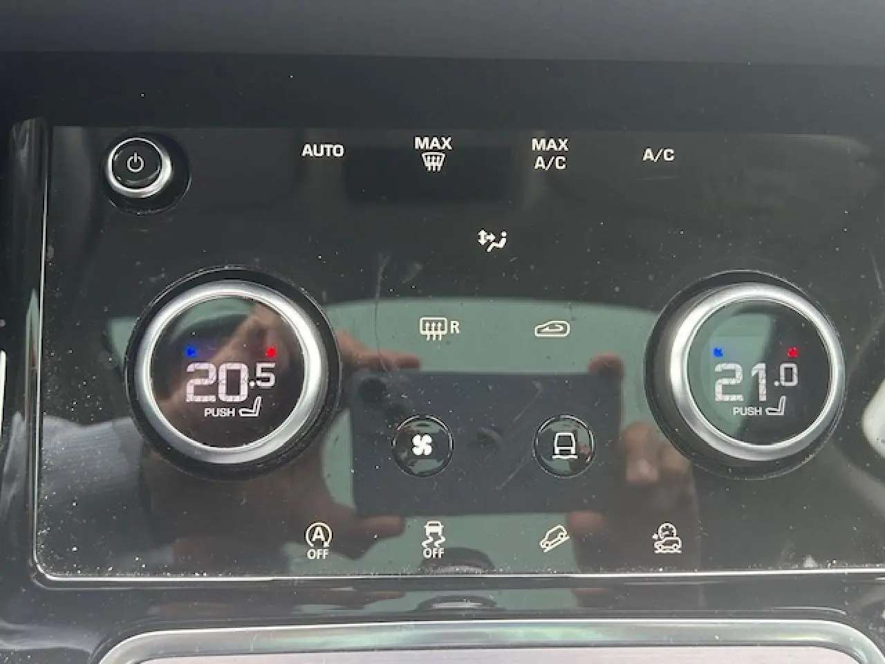 Gros plan sur la commande de climatisation bi-zone du Range Rover Evoque gris foncé, affichant 20,5°C et 21°C.