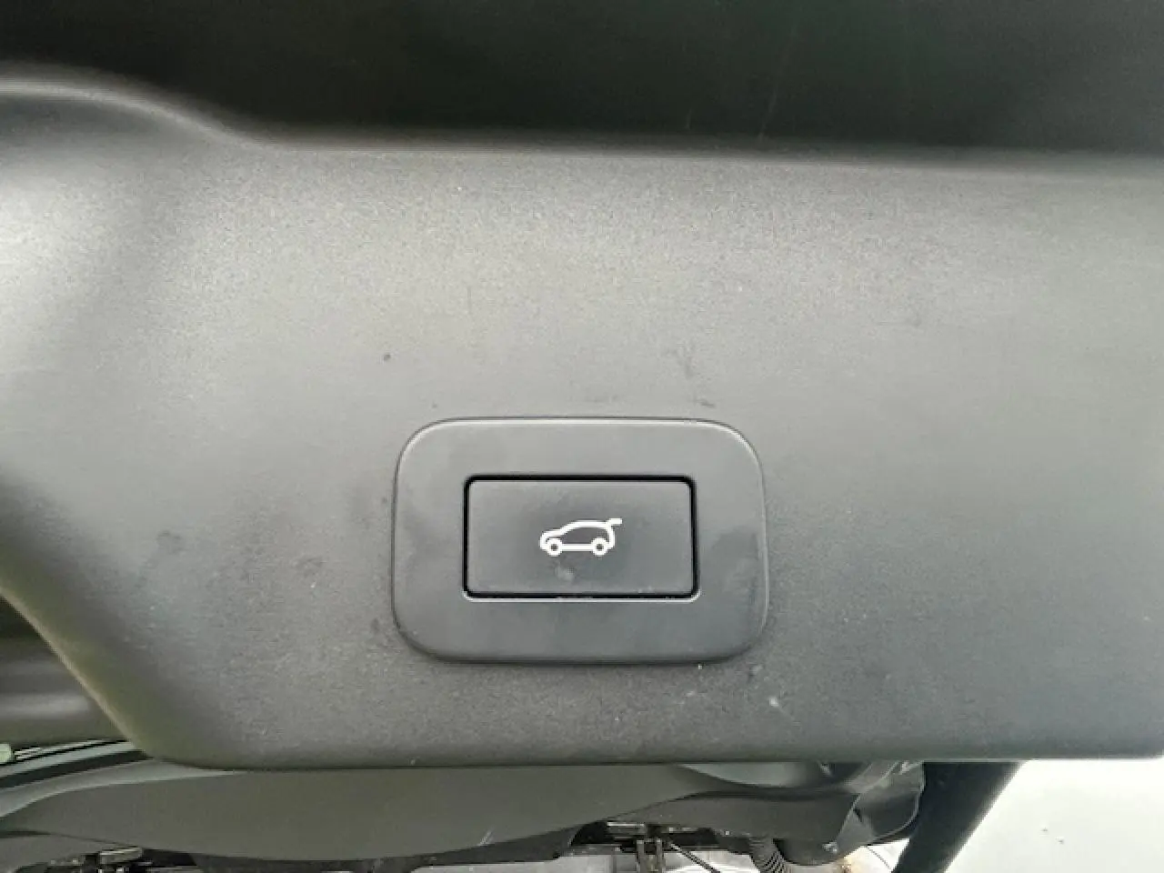 Bouton de hayon électrique mains libres sur le hayon gris foncé métallisé du Range Rover Evoque 2022 vue intérieure arrière.