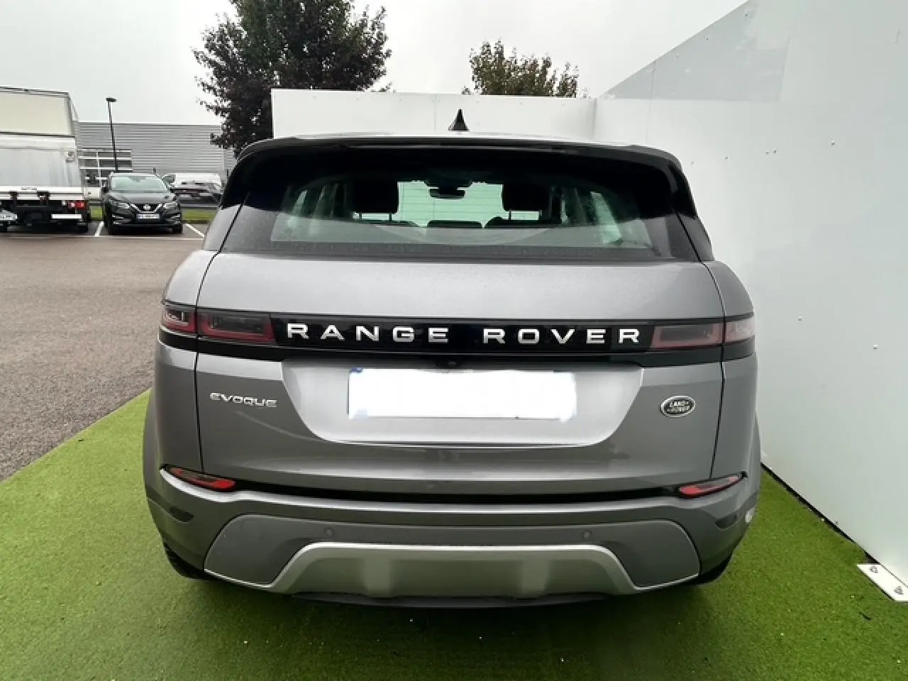 Vue arrière du Range Rover Evoque gris foncé métal avec hayon électrique et feux arrière à LED étirés.