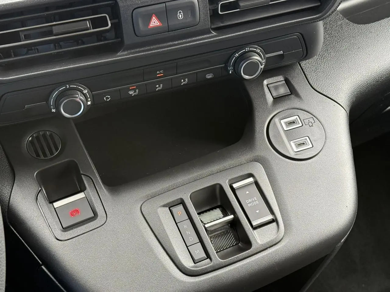 Vue rapprochée de la console centrale noire du Citroën Berlingo 2025 avec commandes de climatisation et boîte automatique.