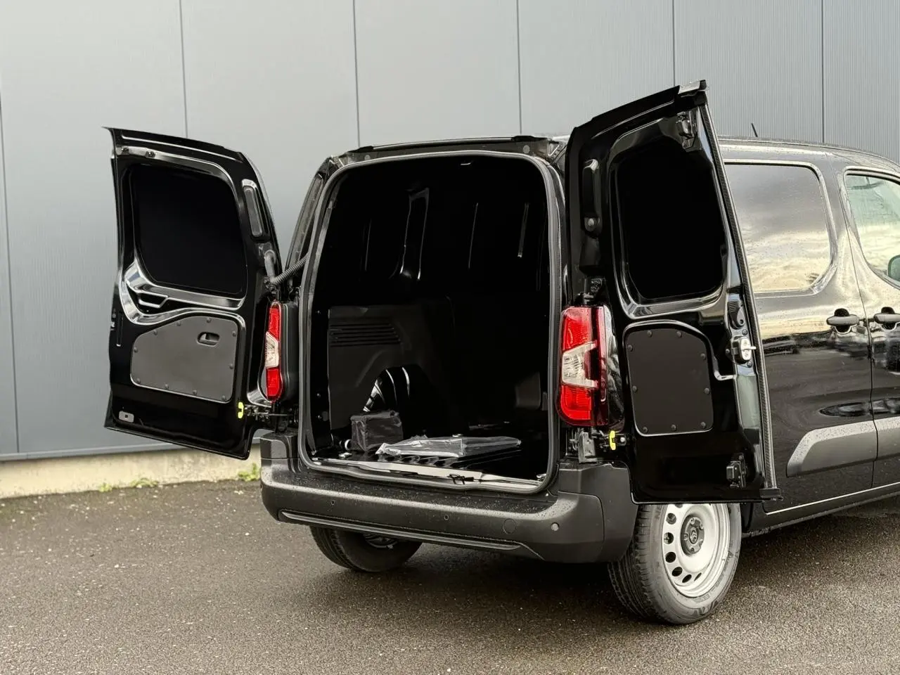 Vue arrière d'un Citroën Berlingo Van noir Perla avec portes battantes ouvertes montrant l'espace de chargement.