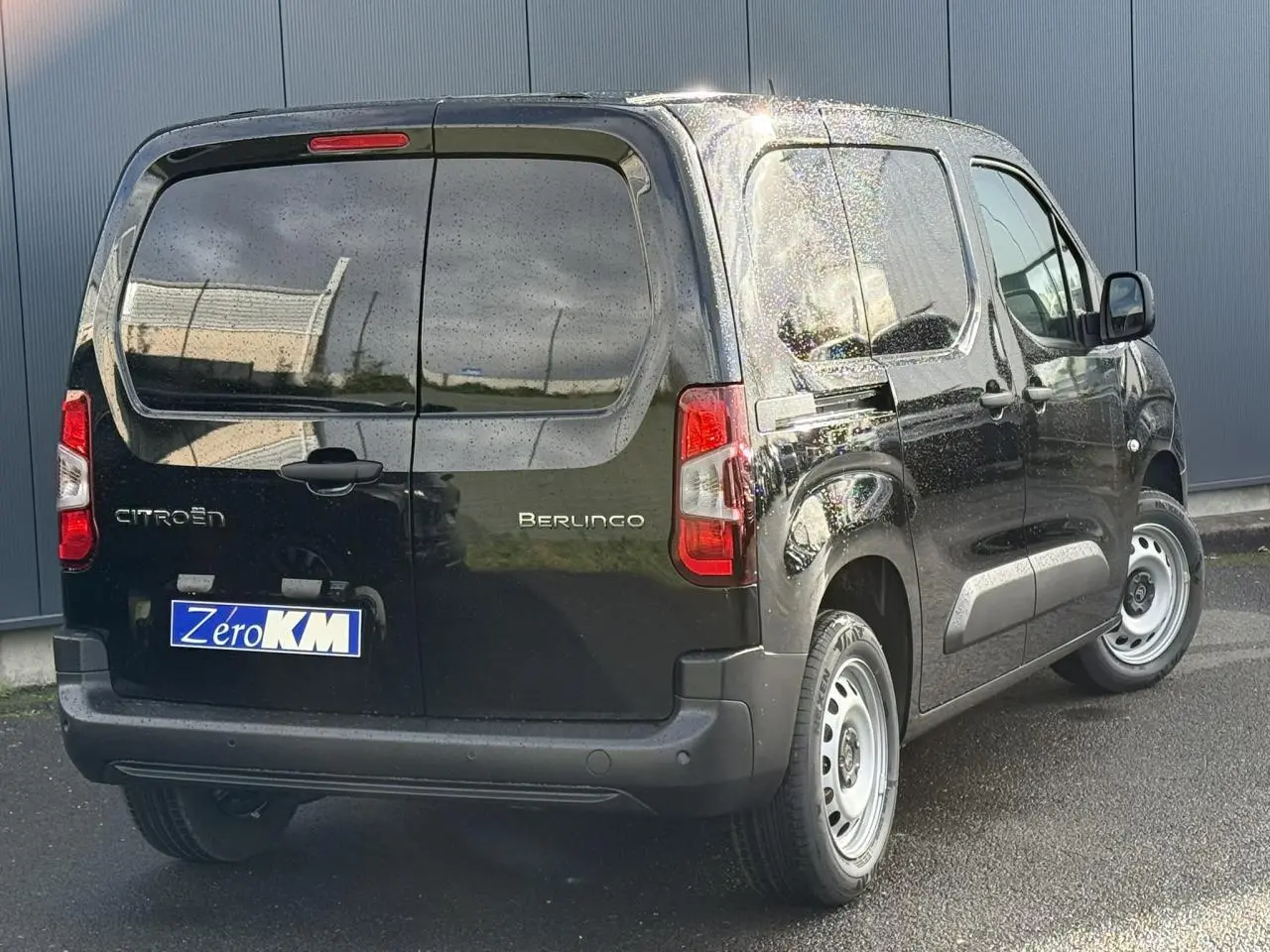 Vue 3/4 arrière droite du Citroën Berlingo noir Perla avec portes arrière battantes tôlées et jantes tôle grises.