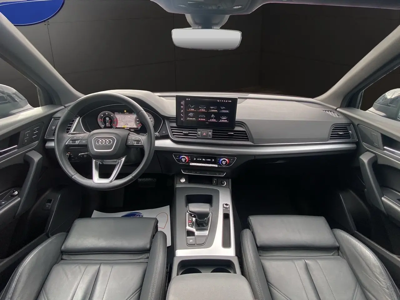 Vue intérieure avant de l'Audi Q5 Business Edition S-Line 2022, avec tableau de bord numérique et sièges sport cuir noir.