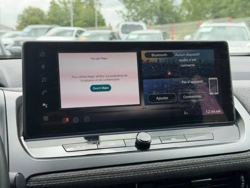 Écran tactile central du Nissan Qashqai 2025 affichant Google Maps et options Bluetooth, intérieur en tissu noir.
