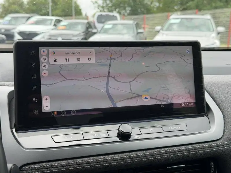 Écran tactile central du Nissan Qashqai 2025 affichant une carte GPS, avec commandes physiques en dessous.