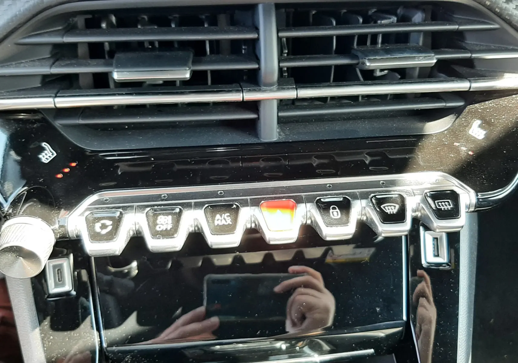 Vue rapprochée de la console centrale noire brillante du Peugeot 2008 1.5 BlueHDi 130ch avec commandes tactiles et aérateurs.