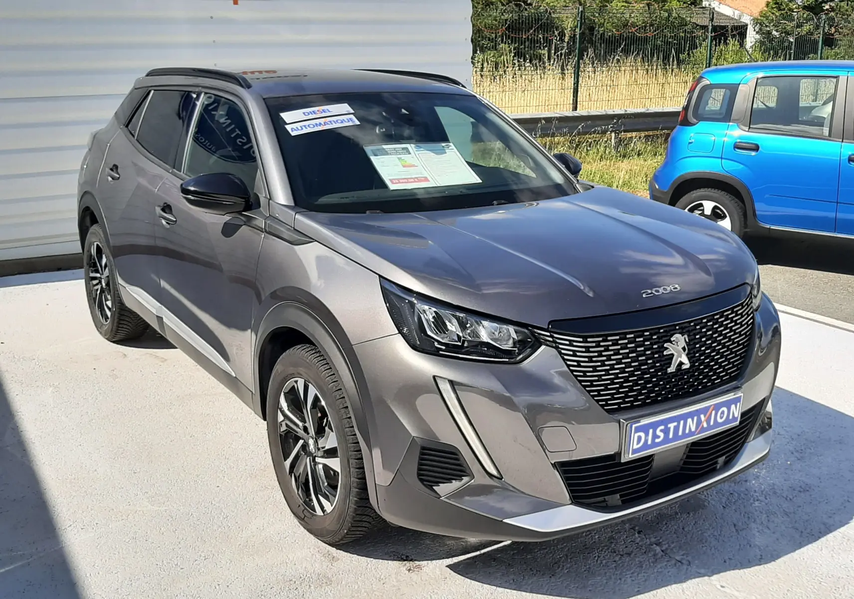 Peugeot 2008 gris platinium en 3/4 avant droit, avec calandre noire et jantes alliage distinctives.