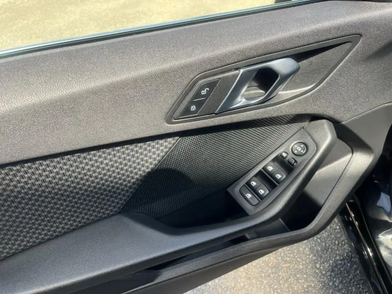 Détail de la porte avant gauche noire d'une BMW Série 1 116dA 2020, avec commandes électriques et poignée intégrée.