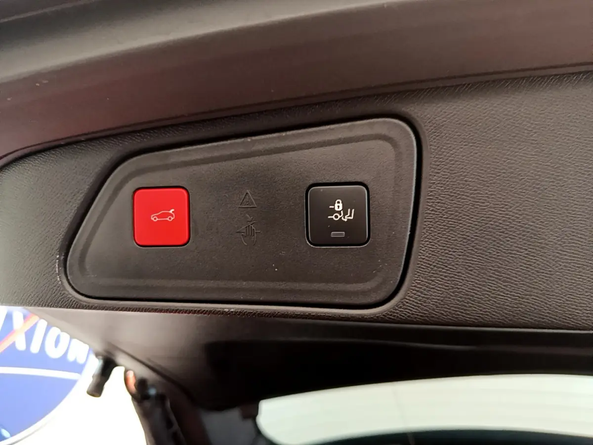 Gros plan sur les boutons d'ouverture et de verrouillage du coffre du Peugeot 3008 noir, vue intérieure arrière.
