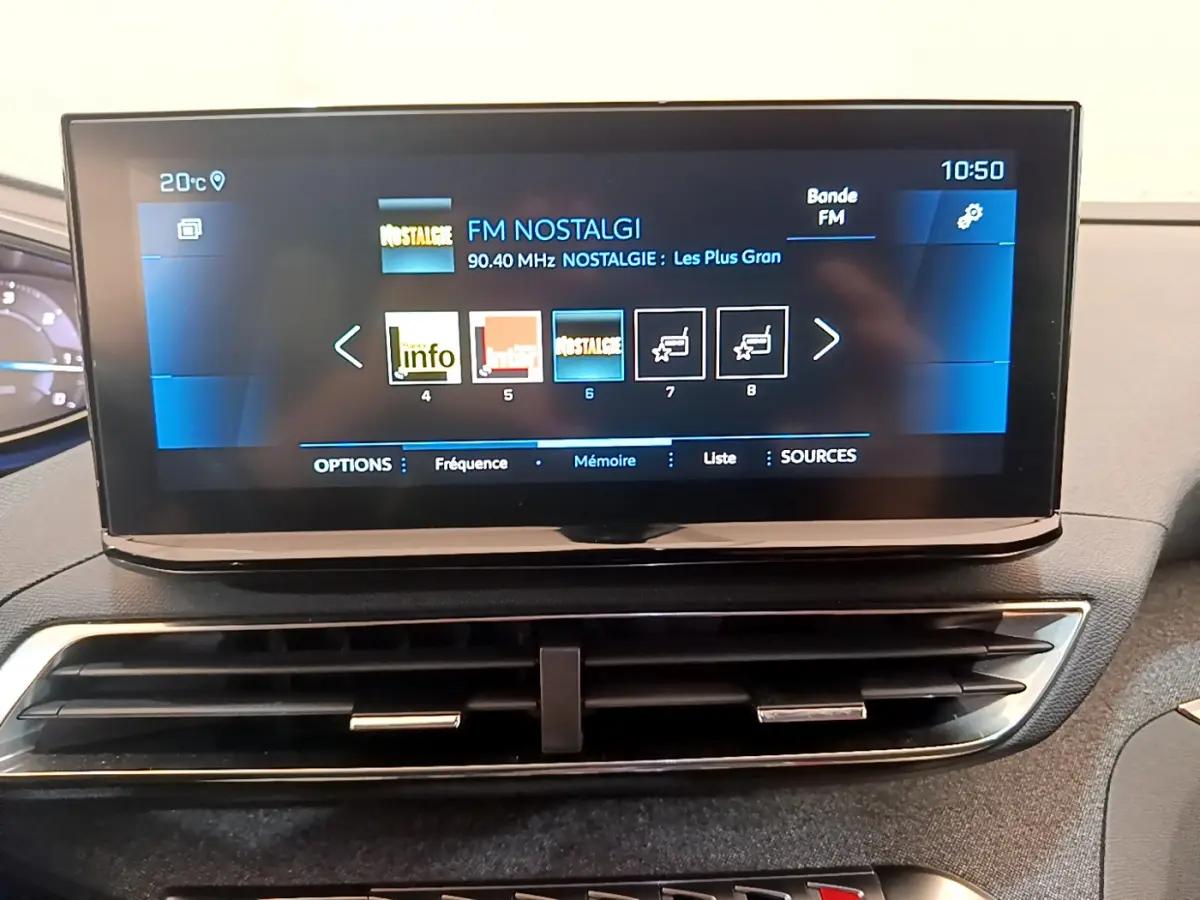 Écran tactile central de 10 pouces affichant la radio FM dans l'habitacle du Peugeot 3008 noir de 2022.