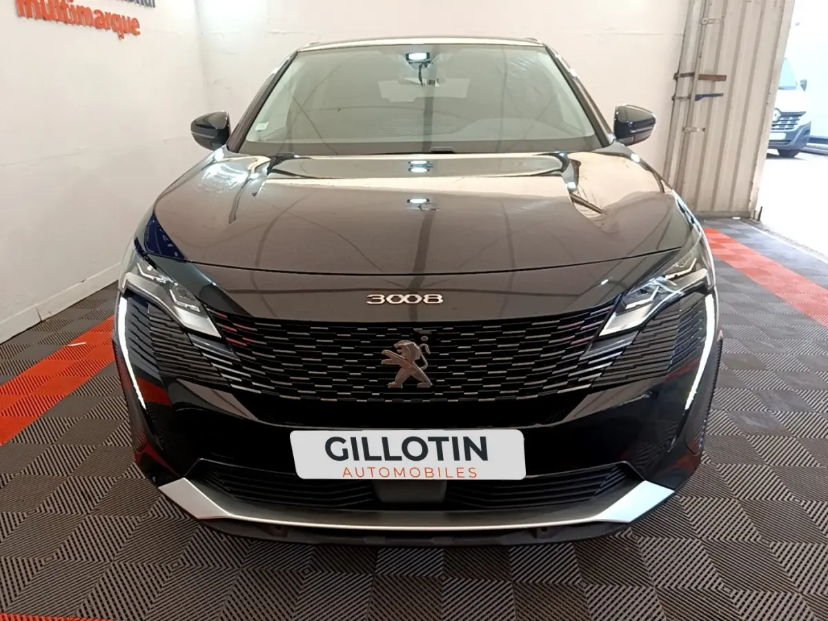 Vue avant d'un Peugeot 3008 noir 2022 avec calandre distinctive et phares LED dans un showroom.