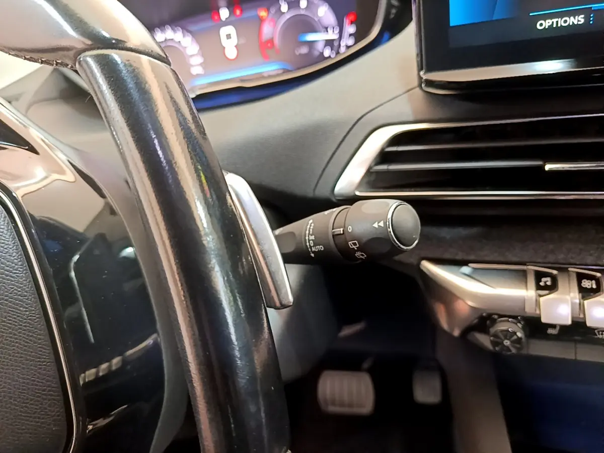 Gros plan sur le volant noir et le tableau de bord numérique lumineux du Peugeot 3008 2022 côté conducteur.