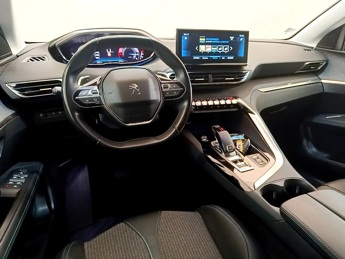 Intérieur du Peugeot 3008 2022 noir, vue du poste de conduite avec tableau de bord digital et écran tactile central.