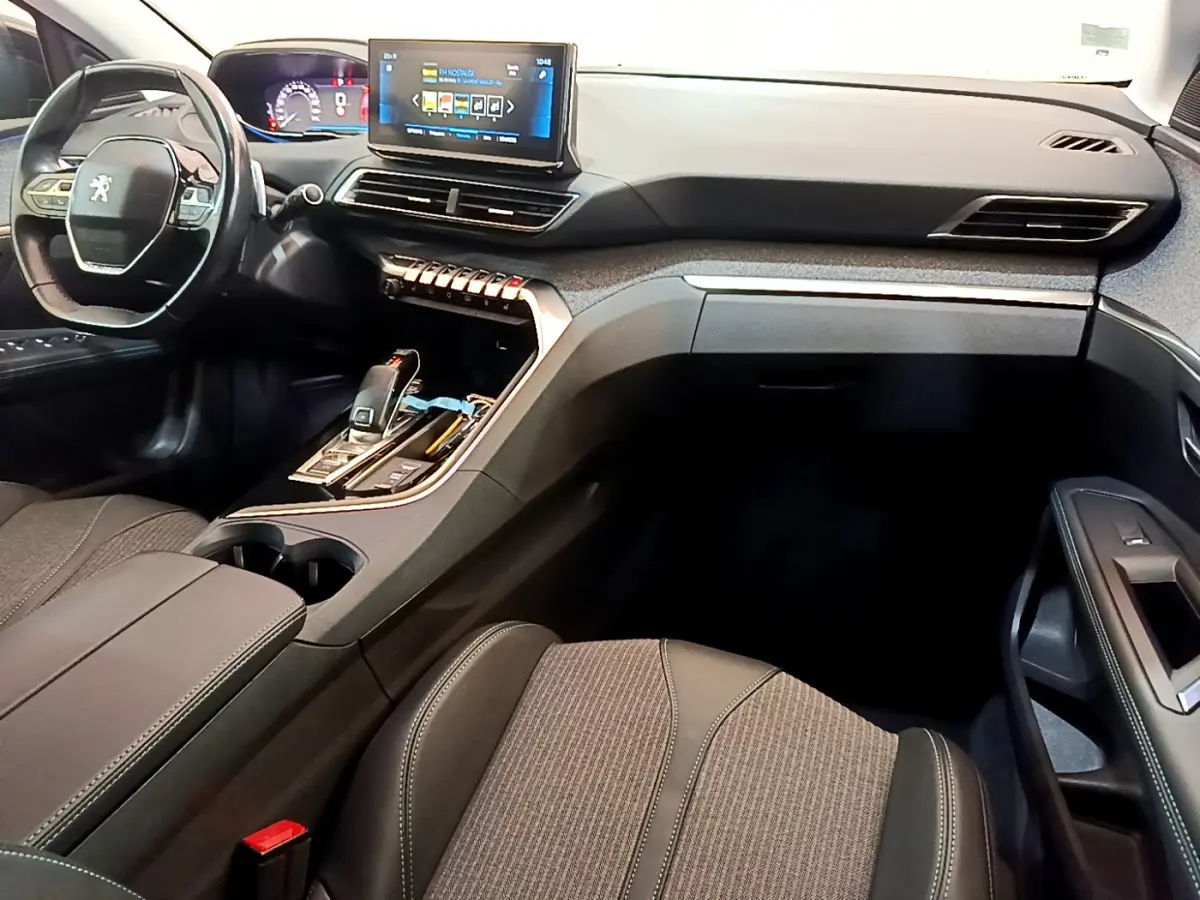 Intérieur du Peugeot 3008 noir, vue côté conducteur, tableau de bord moderne avec écran tactile et volant cuir multifonctions.
