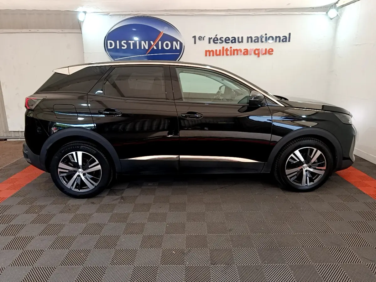 Profil côté gauche d'un Peugeot 3008 noir 2022 dans un showroom avec jantes alliage et vitres teintées.