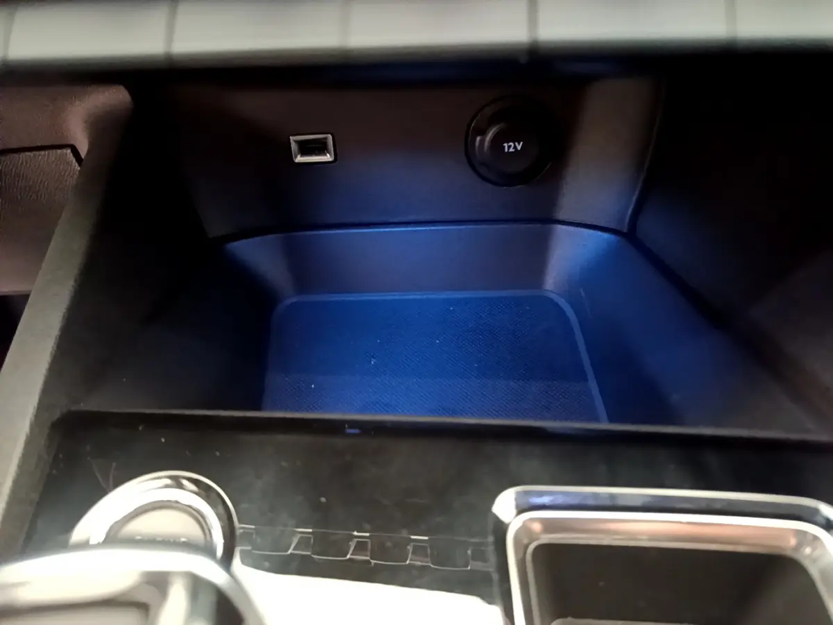 Gros plan sur la console centrale du Peugeot 3008 noir, montrant prise USB et prise 12V sous éclairage bleu.