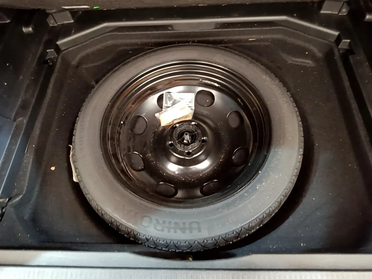 Vue plongeante sur la roue de secours noire dans le coffre du Peugeot 3008 BlueHDi 130 S&S EAT8 Allure Pack 2022.