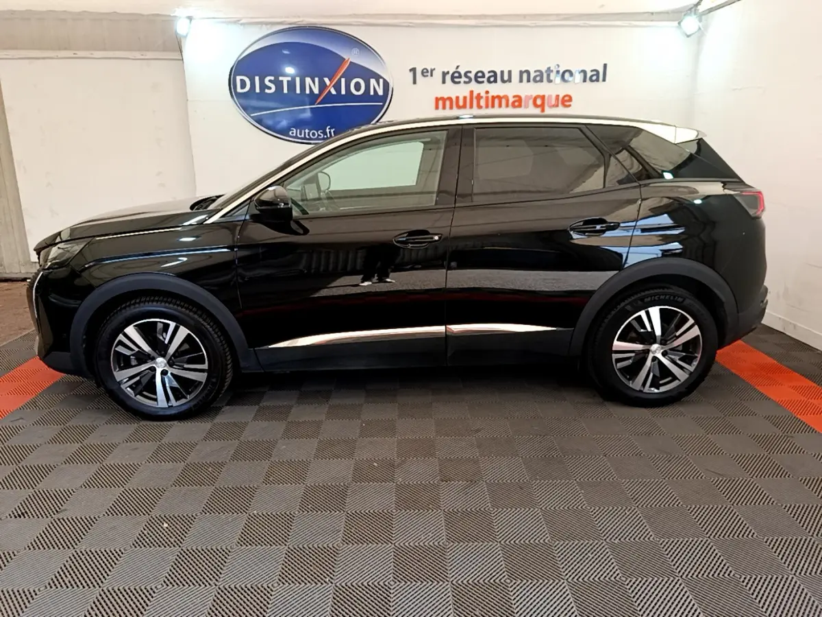 Profil côté gauche d'un Peugeot 3008 noir 2022 Allure Pack, avec jantes alliage et vitres teintées en intérieur showroom.