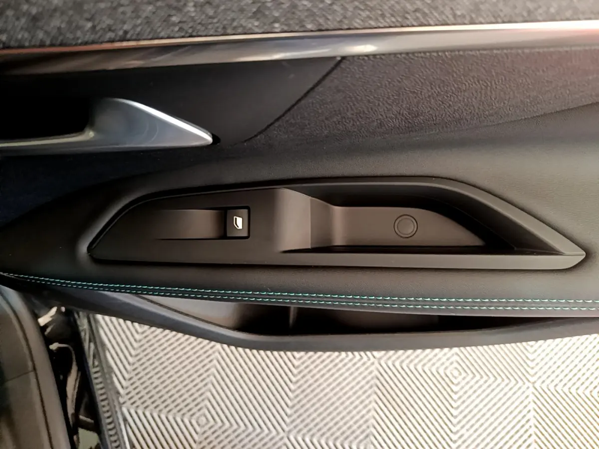 Gros plan sur la commande de lève-vitre côté gauche avec surpiqûres bleues sur la porte noire du Peugeot 3008 2022.